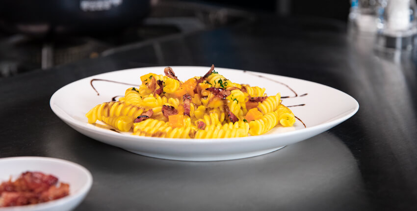 Teller mit Fusilli mit Kürbis, Pancetta und Balsamico-Essig aus Modena