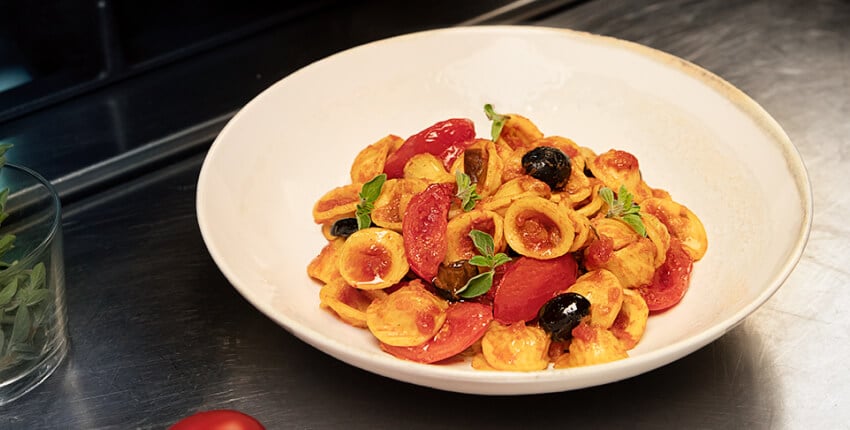 Plat de pâtes Orecchiette aux tomates, olives et aubergines